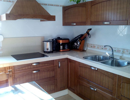Cocina de concepto abierto conectada con el salón, creando un espacio social y funcional